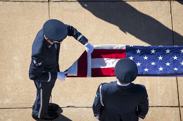 U.S. Air Force Senior Airman Allen Aragon, left, and Senior Airman Anthony Harvey, right, 27th Special Operations Wing honor guardsmen, fold the U.S. flag during a wing retreat ceremony at Cannon Air Force Base, New Mexico, April 17, 2024. The ceremony was held to pay homage to the sacrifices of the 27th Bombardment Group, the original Steadfast Line, who fought as the first and only infantry combat unit in U.S. Army Air Corps history during the Battle of Bataan until they surrendered in April 1942. (U.S. Air Force photo by Staff Sgt. Vernon R. Walter III)